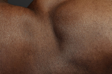 Fototapeta premium Detailed texture of human skin. Close up shot of young african-american male body. Skincare, bodycare, healthcare, hygiene and medicine concept. Looks beauty and well-kept. Dermatology.