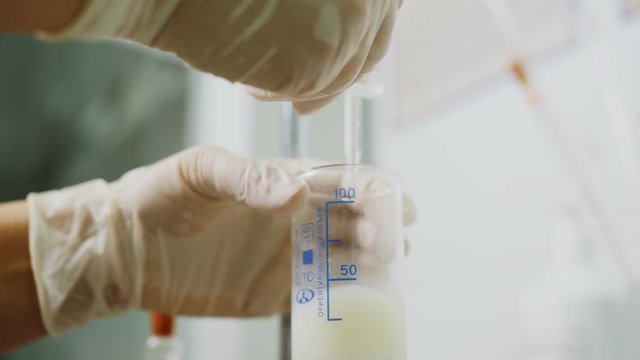 lab assistant adds reagent into testing milk in laboratory