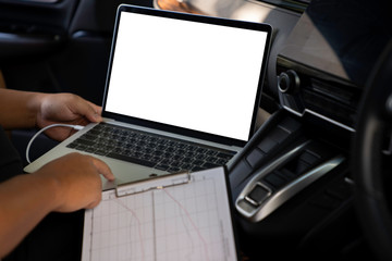 Businessman using laptop computer in car on the road with blank white screen and clipping path. business concept. Mockup with copyspace ready for design or text.