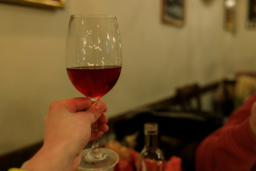 a glass of wine in hand in greece in a restaurant