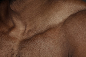 Collarbones. Detailed texture of human skin. Close up shot of young african-american male body....