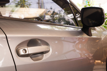 Car door handle or door open of silver bronze car with keyless entry system ,selective focus on keyless entry pad , vehicle technology and security concept