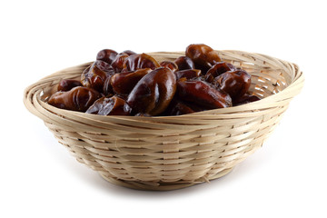 Date fruits on wicked plate isolated on white