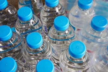Plastic water bottles with blue cap and dozen of bottle with plastic wrap packaging