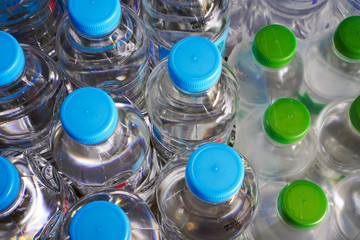 Plastic water bottles with blue cap and dozen of green cap bottle with plastic wrap packaging