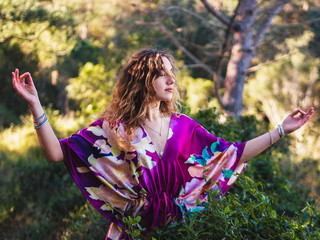 woman with brown hair dressed in a hand-painted silk kimono in nature breathing and relaxing