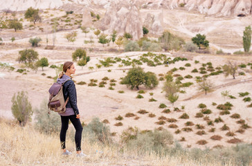 Naklejka na ściany i meble Travel concept. Travelling young woman with backpack enjoying mountains view.