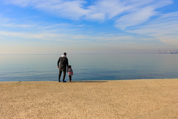 man and child by the sea