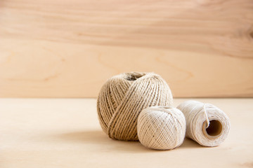 beige threads, twine on wooden background