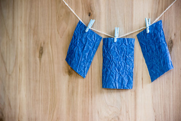 three blue sheets on clothespins hang on thread