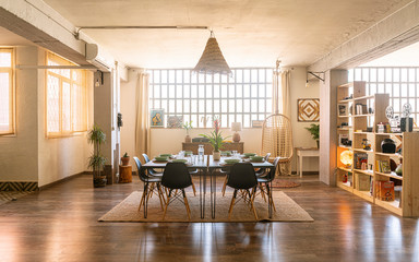 Interior home design / decoration. Spacious dining room in bright industrial loft with shelves,...