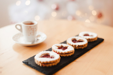 Italian coffee small Cup and cookie on the table near the Christmas tree with golden bokeh
