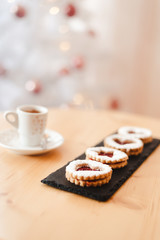 Italian coffee small Cup and cookie on the table near the Christmas tree with golden bokeh