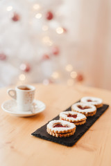 Italian coffee small Cup and cookie on the table near the Christmas tree with golden bokeh