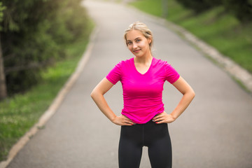 beautiful young woman in sportswear in a summer park plays sports