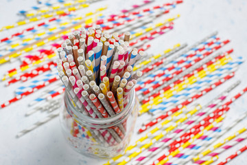 Paper straws of different colors on light background with copy space