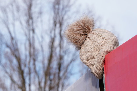 The Light Knitted Hat Was Lost Or Forgotten And Hung Over The Fence. Warehouse Lost And Found, Lost Things, Inattentive Or Forgetful People.