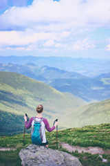 Naklejka na ściany i meble Active lifestyle. Traveling, hiking and trekking concept. Young woman with backpack in the Carpathian mountains.
