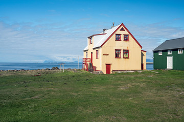 Colorful buildings and the charming city of Flatey Island in Iceland just outside Stykkisholmur and the Westfjords. Blue sky and sunny weather. Explore and traveling concept.