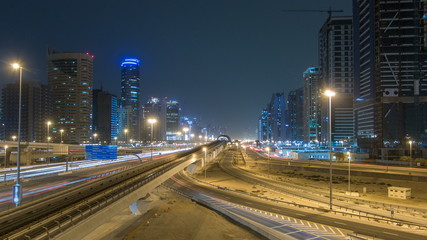 Fototapeta na wymiar Sheikh Zayed road traffic night timelapse and Dubai Metro. Dubai, UAE.