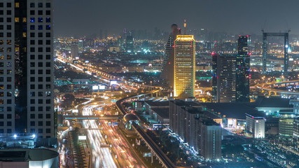 Scenic Dubai downtown architecture night timelapse. Top view over Sheikh Zayed road with illuminated skyscrapers and traffic.