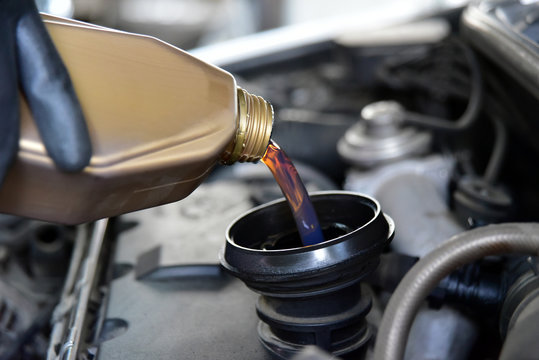 adding oil to the car engine
