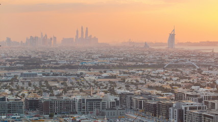 Dubai skyline with Dubai Marina skyscrapers and coastline at sunset timelapse with seven star luxury hotel in Dubai, UAE.