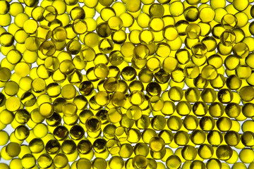 Linseed oil capsules are bright yellow in the contrast light, similar to eggs. Backgrounds texture design.