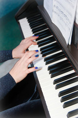Fototapeta premium musician's female hands with manicure and white black piano keys while playing music