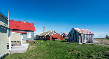 Colorful buildings and the charming city of Flatey Island in Iceland just outside Stykkisholmur and the Westfjords. Blue sky and sunny weather. Explore and traveling concept