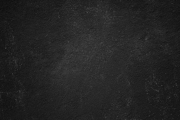 Abstract black painted stony texture of a rocky plastered wall surface for backgrounds.