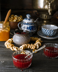 Traditional Russian tea table setup with jam, honey, bagels on dark rustic background