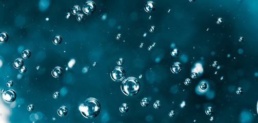 Bubbles of air on the smooth surface of blue water as an abstract background
