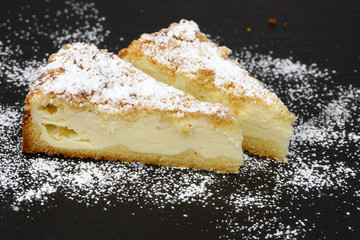 pieces cheesecake with crumble on black plate