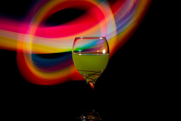 Glass with a drink on a colorful black background