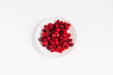 White plate with raspberries. Fresh raspberries isolated on white background.