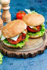 Delicious fresh homemade burgers on dark background