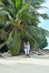 Happy elderly couple hugging on tropical beach
