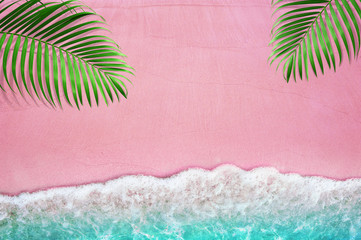 Tropical green palm leaves as frame with pink color of sandy beach and soff blue ocean wave and...