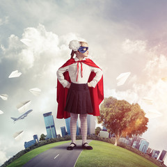 Girl power concept with cute kid guardian against cityscape background