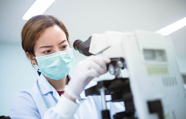 medical technician look at the microscope  in medical laboratory
