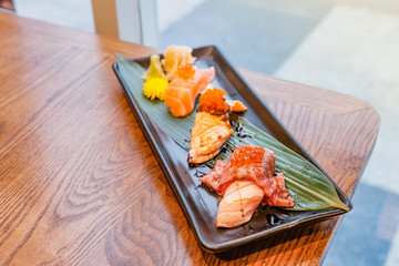 Japanese food, a set of sushi put on a rectangular plate placed on wooden table