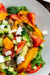 Detox healthy dinner from Quinoa Salad with vegetables such as cucumbers, cherry tomatoes, pepper and goat cheese. Vegetarian food.