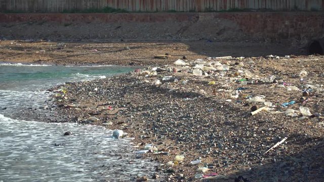 Plastic bottles and other waste Was thrown onto the beach and in the ocean. Concepts of environmental pollution problems