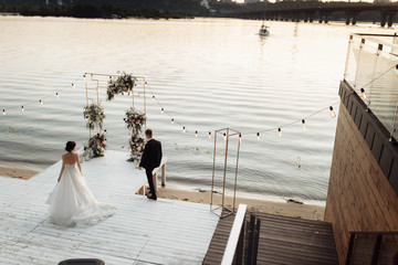Obraz premium Portrait of wedding couple on sunset near the river