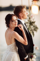 Fototapeta premium Portrait of wedding couple on sunset near the river