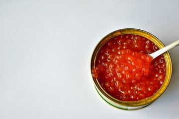 The large jar of red caviar with the spoon