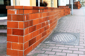 Winding masonry partition is decorated with red brick imitation