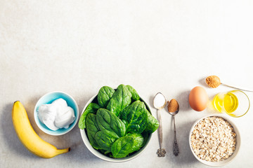 Ingredients for healthy green pancakes such as spinach, coconut milk, banana, egg and oats....