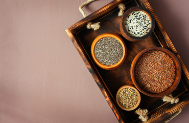 Different seeds in a wooden box, chia, hemp, sesame and flax, flat lay, top view, copy space